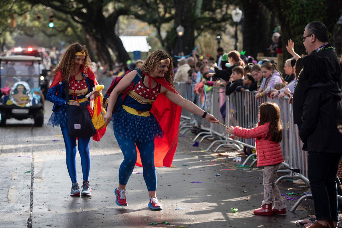 Women dressed as Wonder Woman hand out throws during the Krewe of Unique Parade following The Ocean Springs Elks Carnival Parade in downtown Ocean Springs on Saturday, Jan. 27, 2024.