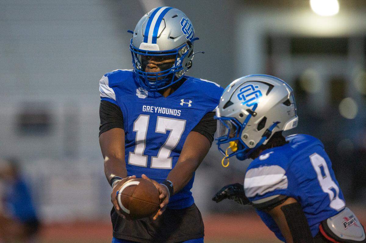 Ocean Springs’ quarterback Connor White hands the ball off to Will Smith Jr. during a game against Madison Central at Greyhound Stadium in Ocean Springs on Friday, Aug. 30, 2024.