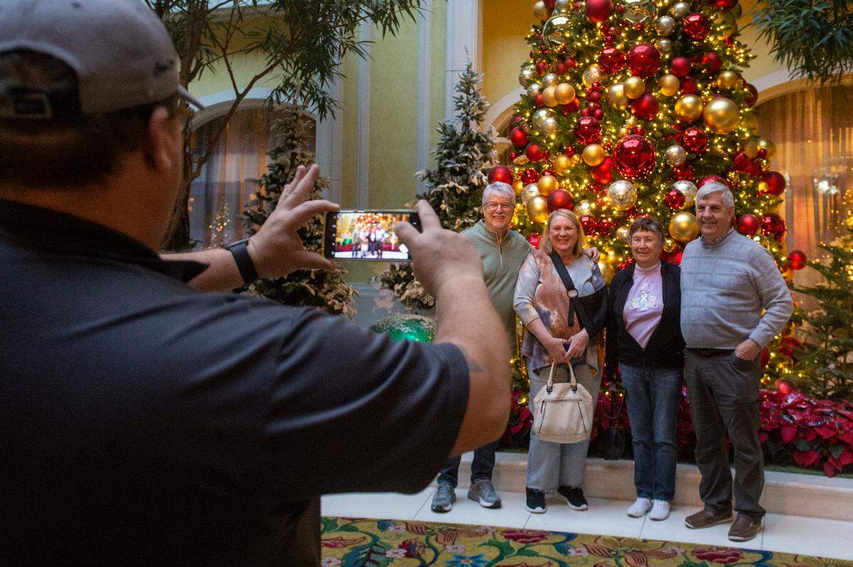 Friends from Illinois and Texas take a photo in front of a Christmas display at the Beau Rivage Casino in Biloxi on Thursday, Dec. 1, 2022.