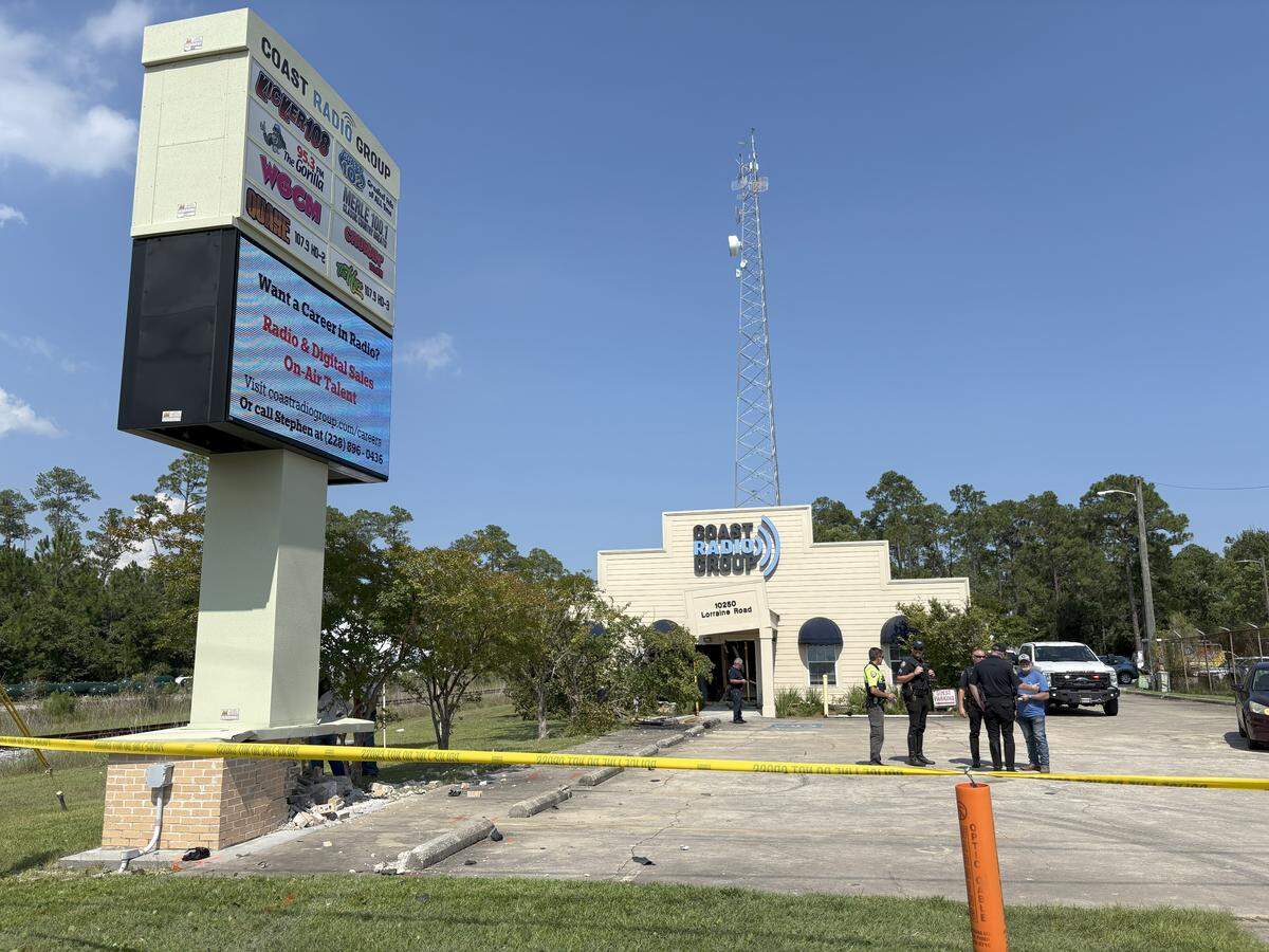 Damage can be seen Friday, Aug. 1, 2025, after a car sped through an intersection and into the front of the Coast Radio Group building in Gulfport.