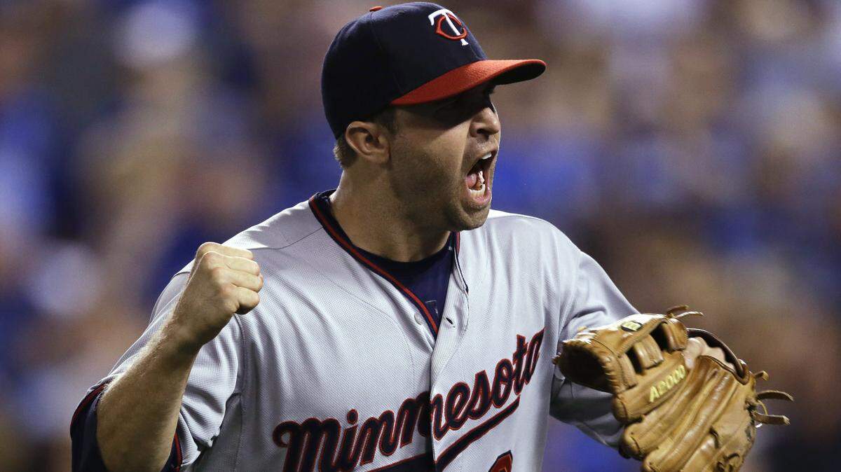 Minnesota Twins second baseman Brian Dozier celebrates the final out of the ninth inning of a baseball game against the Kansas City Royals at Kauffman Stadium in Kansas City, Mo., Friday, July 3, 2015.