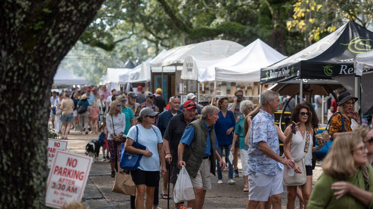 People walk among tents selling art along Washington Avenue during the Peter Anderson Festival in Ocean Springs on Sunday, Nov. 6, 2022.