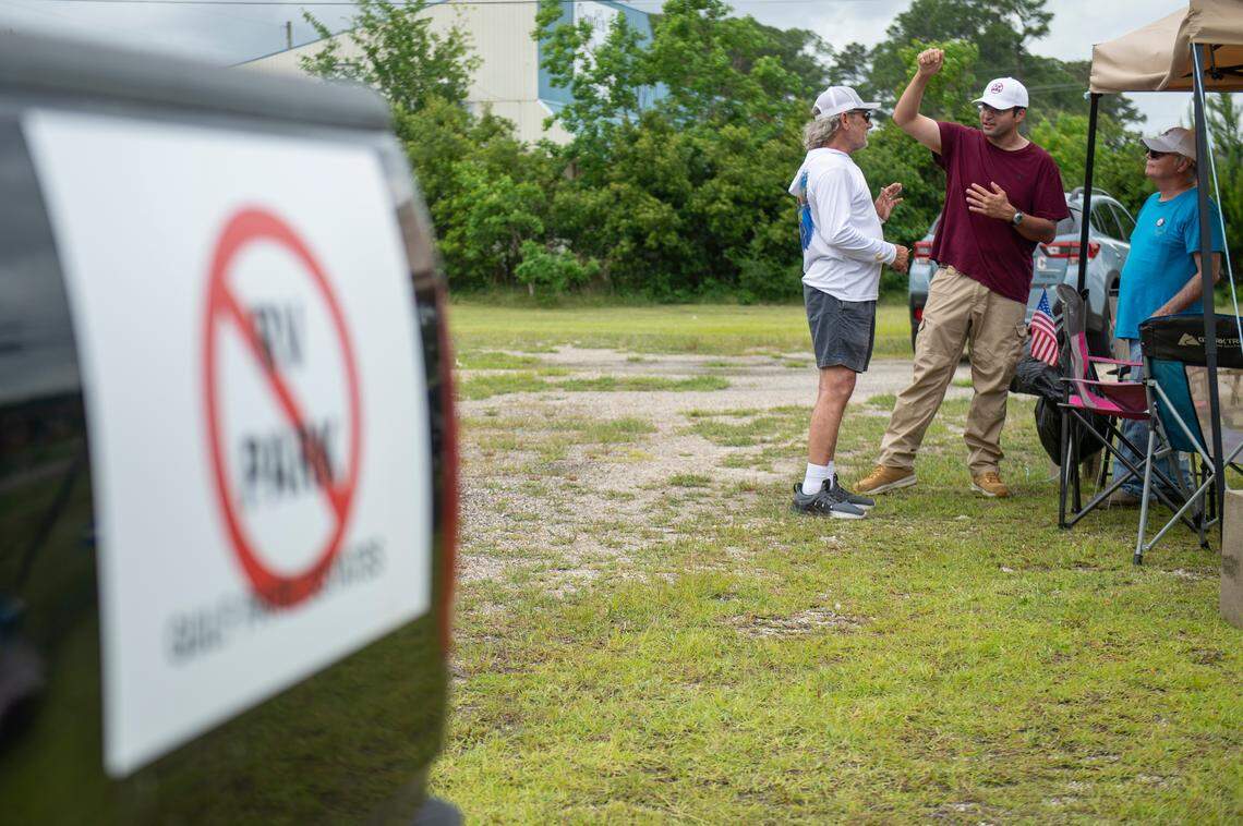Eamon Mohiuddin, center, who is against the development of an RV park in Gulf Park Estates and filed a lawsuit in attempt to stop it, shares his cause at a tent that he set up to give out signs on Beachview Drive on Thursday, May 2, 2024.