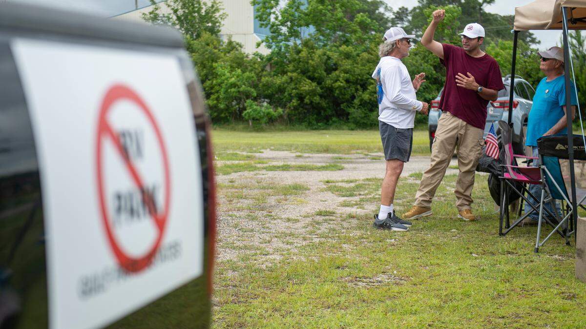 Eamon Mohiuddin, who is against the development of an RV park in Gulf Park Estates and filed a lawsuit in attempt to stop it, shares his cause to Ross Broussard, who is undecided on the RV park, at a tent Mohiuddin set up to give out signs on Beachview Drive on Thursday, May 2, 2024.