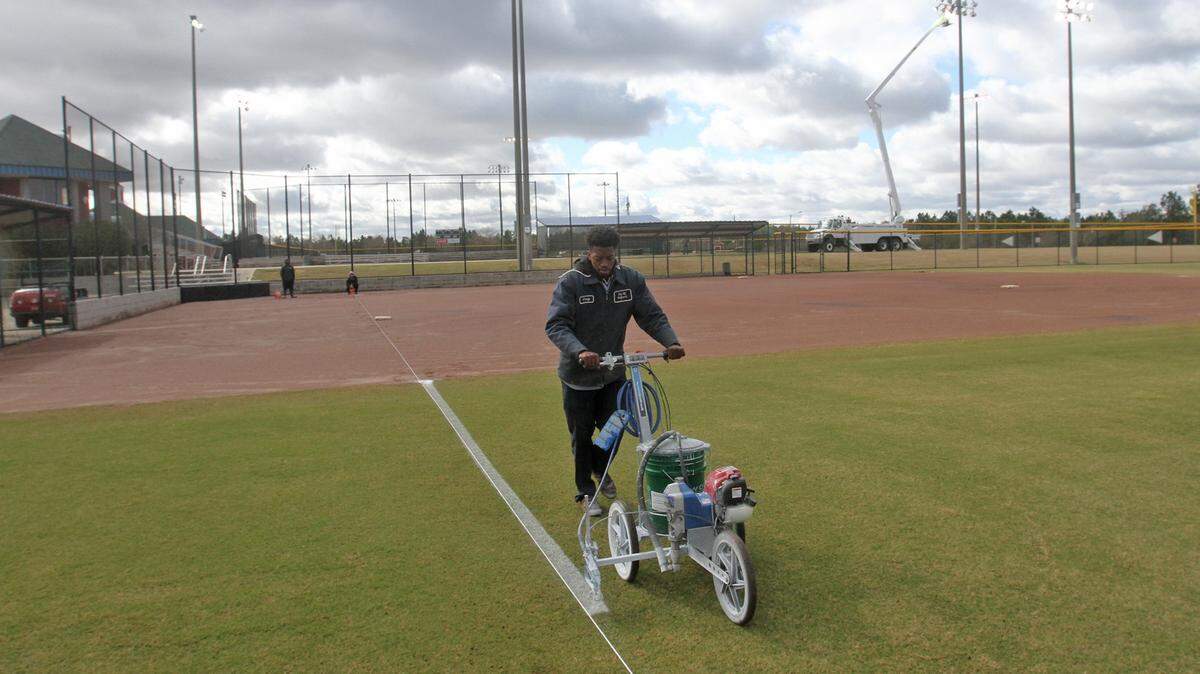 Craig Johnson paints lines on one of the fields at the Gulfport Sportsplex before the Mississippi Gulf Coast Softball Classic.