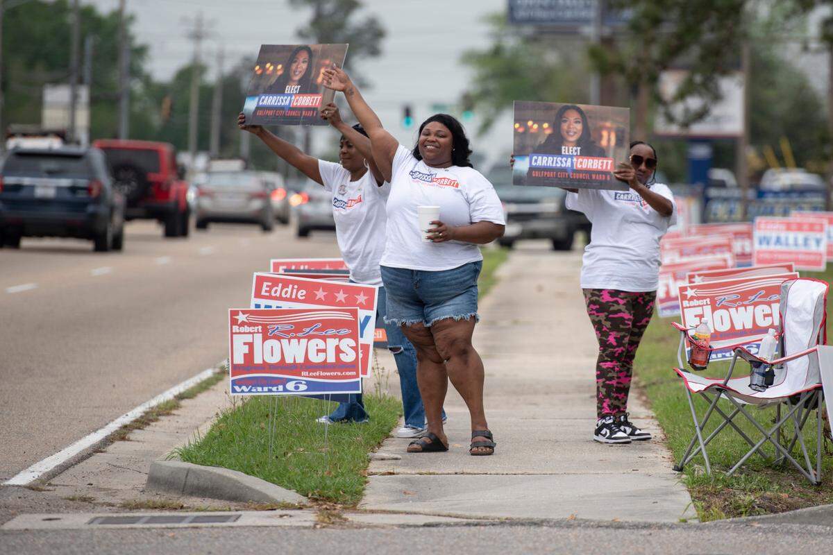 Supporters of Carrissa Corbett campaign outside a polling place at Orange Grove Community Center in Gulfport on April 1.