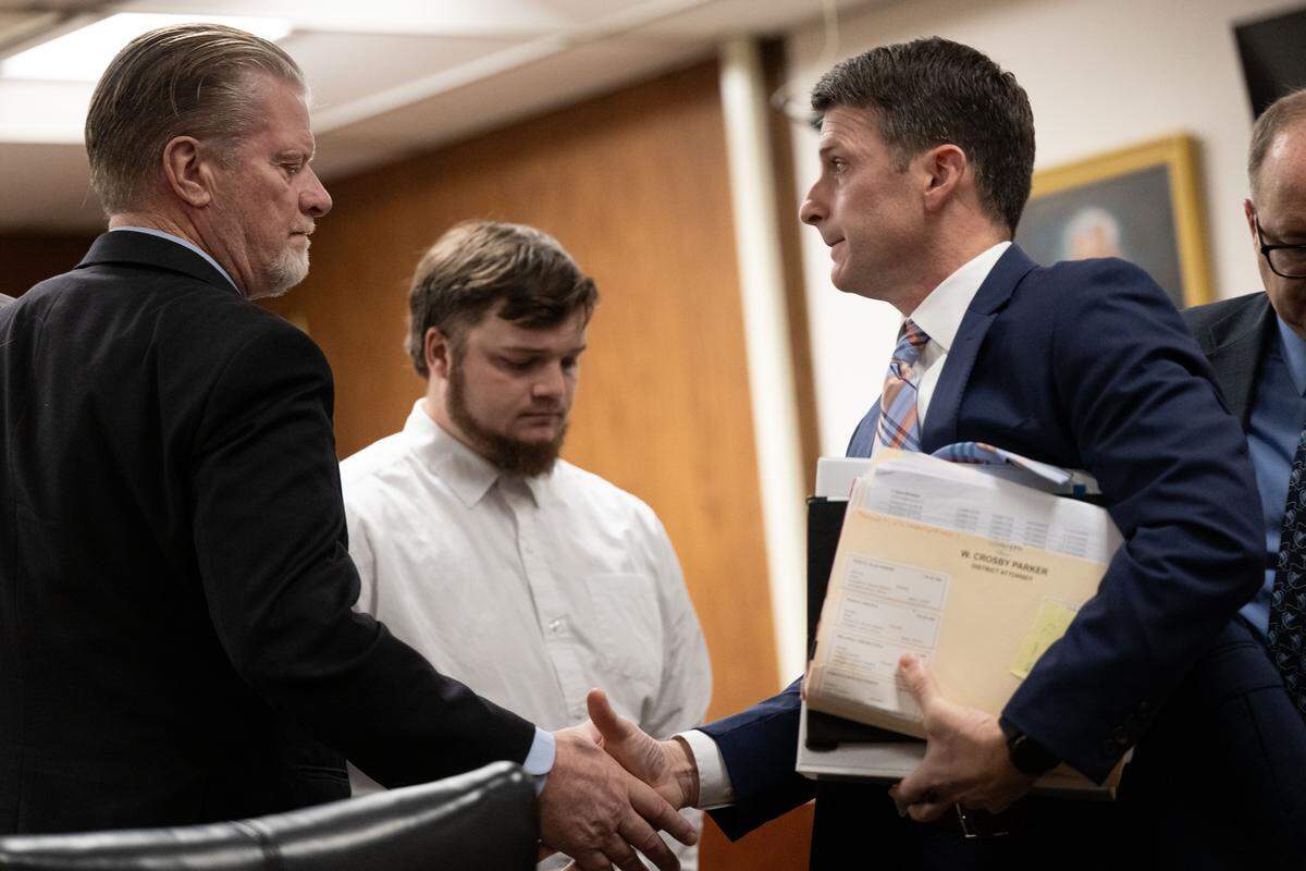 Attorney Chris Johnson, left, shakes hands with Assistant District Attorney Matthew Burrell, right, after a guilty plea at Harrison County Court in Gulfport on Tuesday, Jan. 13, 2026.
