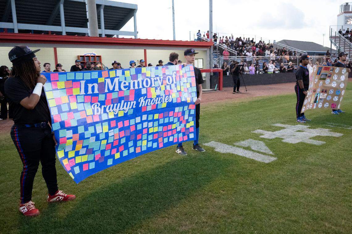 Pascagoula players hold up signs honoring Braylyn Knowles before Thursday’s game.