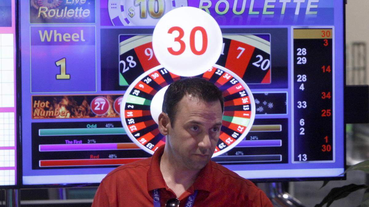 TIM ISBELL/SUN HERALDAdam Thibault works on Live Roulette wheel at IGT display Tuesday. A camera over the wheel projects the spinning wheel on the screen.