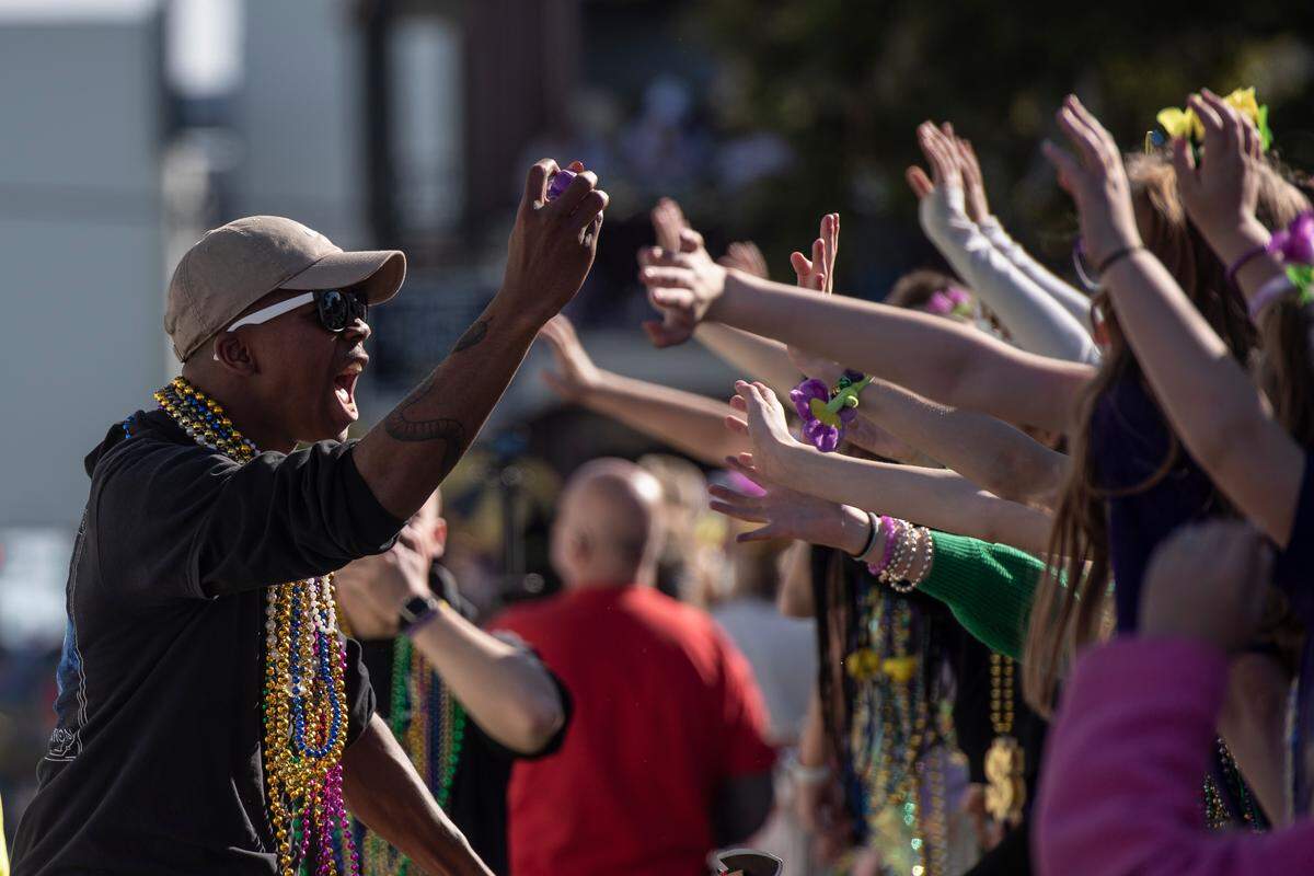 A float rider throws beads during the Gulf Coast Carnival Association’s Mardi Gras parade in Biloxi on Tuesday, Feb. 13, 2024.