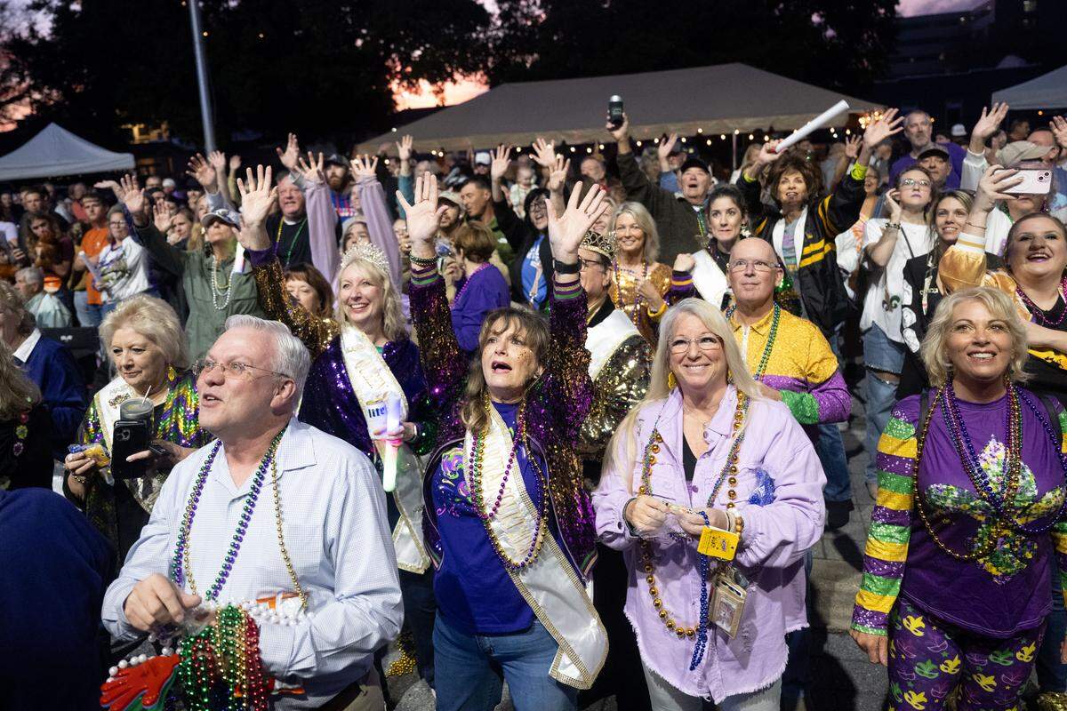 Crowd members cheer for Mardi Gras beads as parade floats pass by during a 12th Night Celebration in Biloxi on Monday, Jan. 5, 2026.
