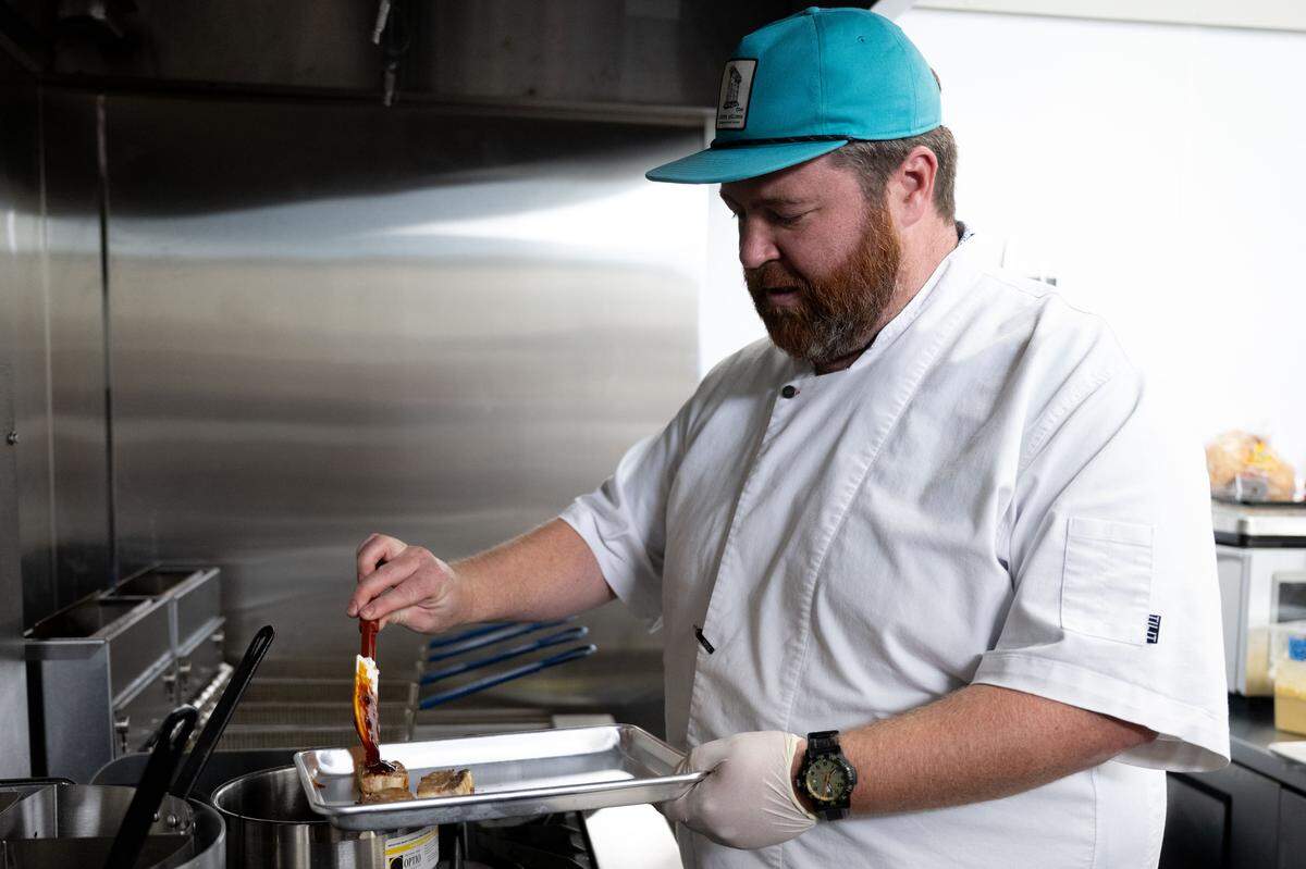 Chef Austin Sumrall prepares Korean pork belly sliders at Chandeleur Depot Brewpub in Pascagoula.