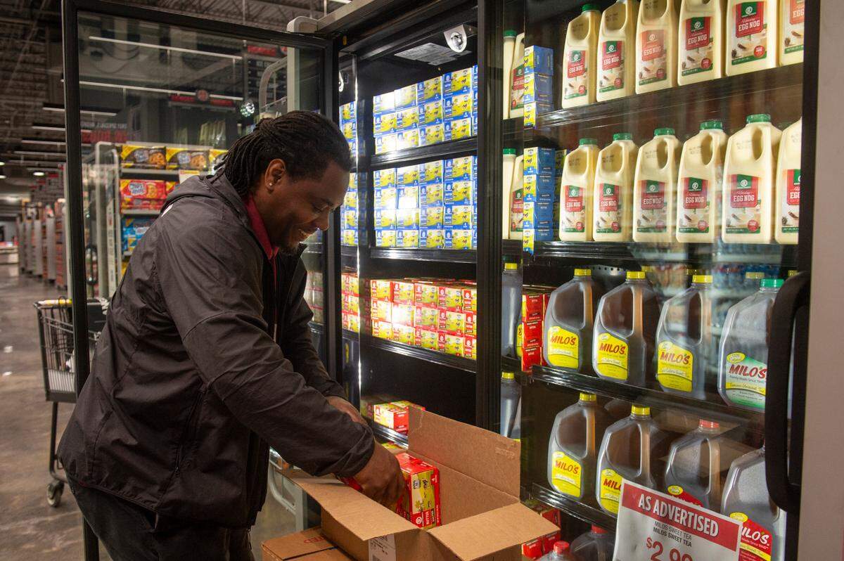 A worker stocks eggnog and other products at the new Rouses Market location on Pass Road in Biloxi on Tuesday, Oct. 15, 2024.