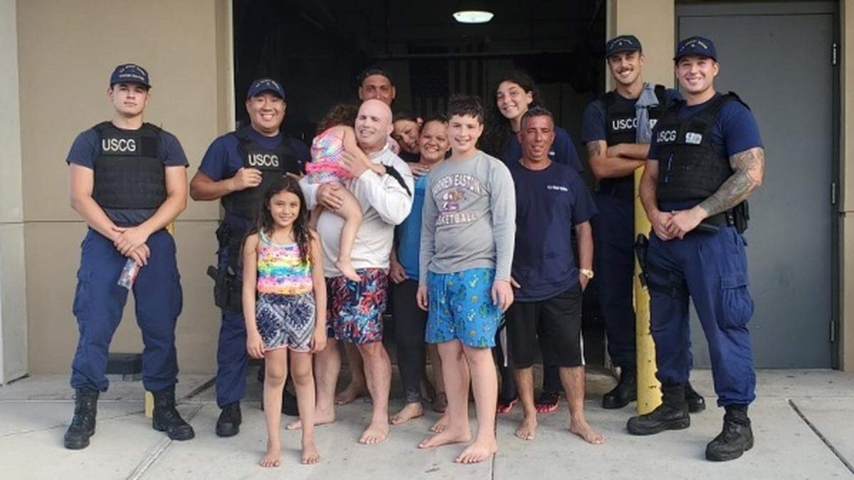 A response boatcrew from Coast Guard Station Gulfport, Mississippi, stands with survivors they rescued from the water after the their vessel capsized offshore Gulfport Harbor Sept. 21, 2019. The boat crew transported the five people to Station Gulfport in stable condition.