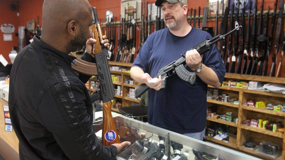 JOHN FITZHUGH/SUN HERALDJason Deere of Biloxi, right, shows Noel White of Biloxi a pair of semi-automatic weapons at Cook's Gun Shop in D'Iberville on Thursday. White, a longtime enthusiast, said American society might have been better off without the Second Amendment right to bear arms, but the prevalence of guns can't be undone now.