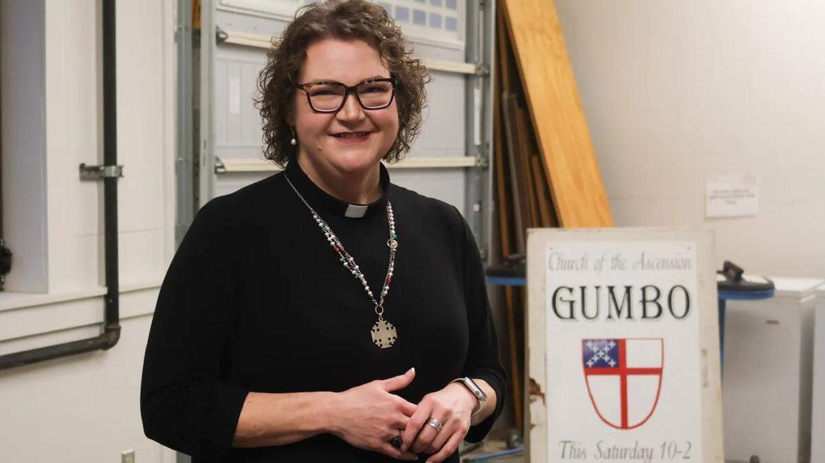 Rev. Jenny Newman, rector of The Episcopal Church of the Ascension, stands in front of a sign stored in the gumbo storage room at the Hattiesburg, Miss., Thursday, Jan. 25, 2024. Ascension’s Ministry of the Pots makes gumbo twice a year, selling about 2,000 quarts a year with proceeds benefiting church outreach programs.