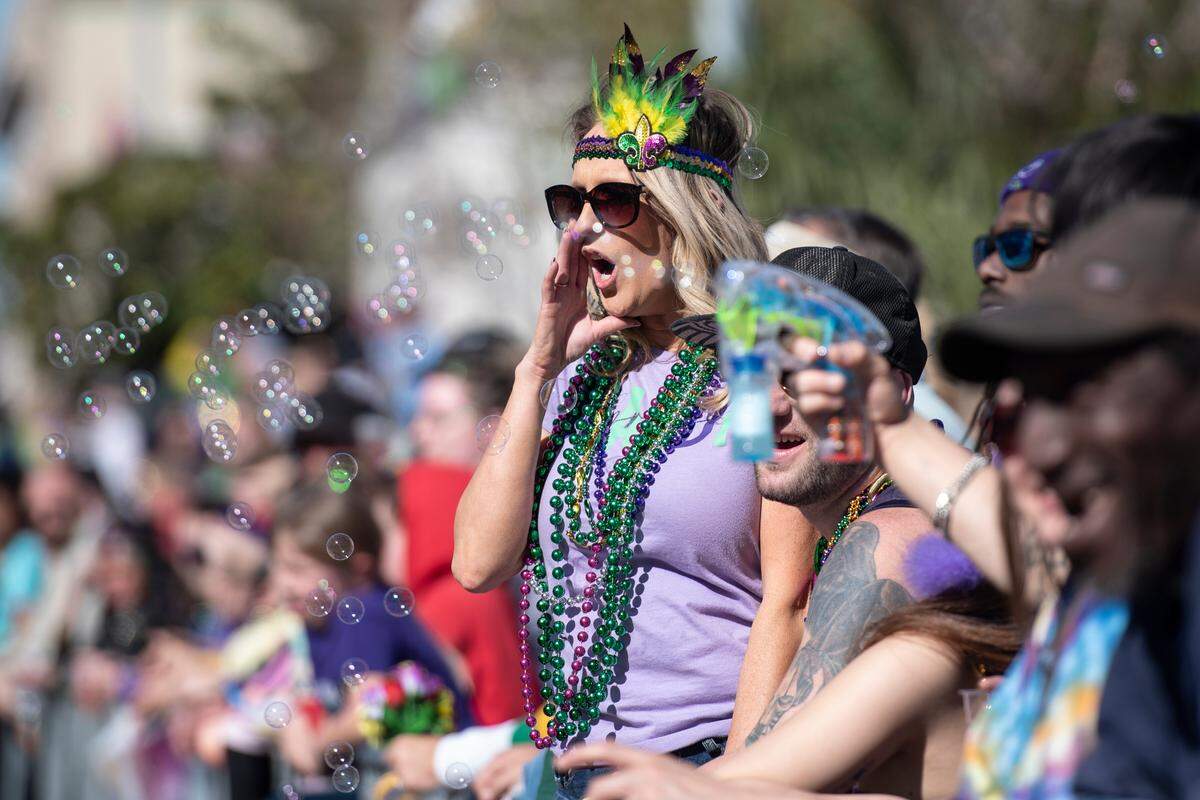 Paradegoers cheer for beads during the Gulf Coast Carnival Association’s Mardi Gras parade in Biloxi on Tuesday, Feb. 13, 2024.