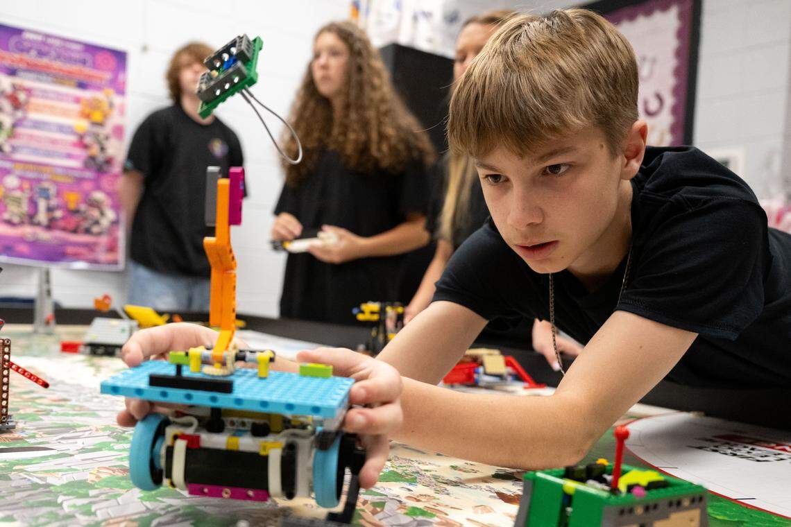 Roman Hart adjusts his team’s robot during a test run at D’Iberville Middle School on Wednesday.