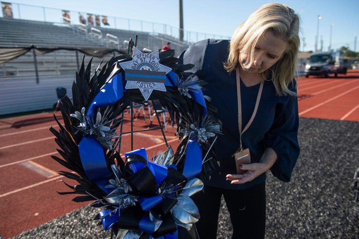 Bay High School Principal Amy Necaise sets up wreaths honoring fallen officers Steven Robin and Branden Estorffe before a vigil at Bay High’s football stadium in Bay St. Louis on Thursday, Dec. 15, 2022.