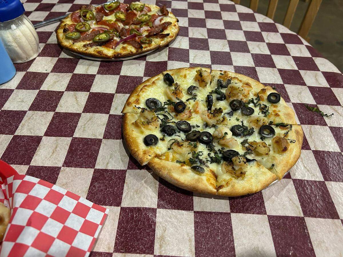 A custom pizza with olives, grilled onions and grilled shrimp from Tom’s Extreme Pizzeria in Ocean Springs, Mississippi.