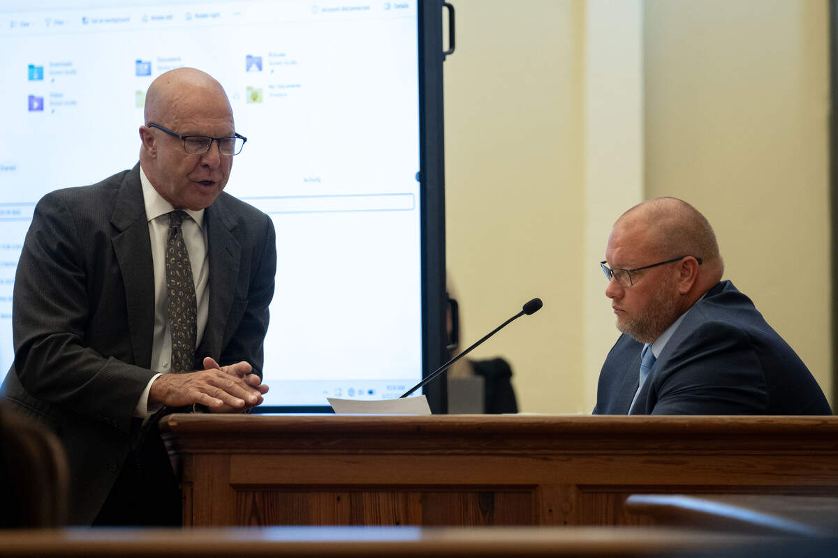 Attorney H.H. “Tracy” Klein, left, leans on the witness stand as he talks to Waveland Assistant Police Chief Eddie Hursey.