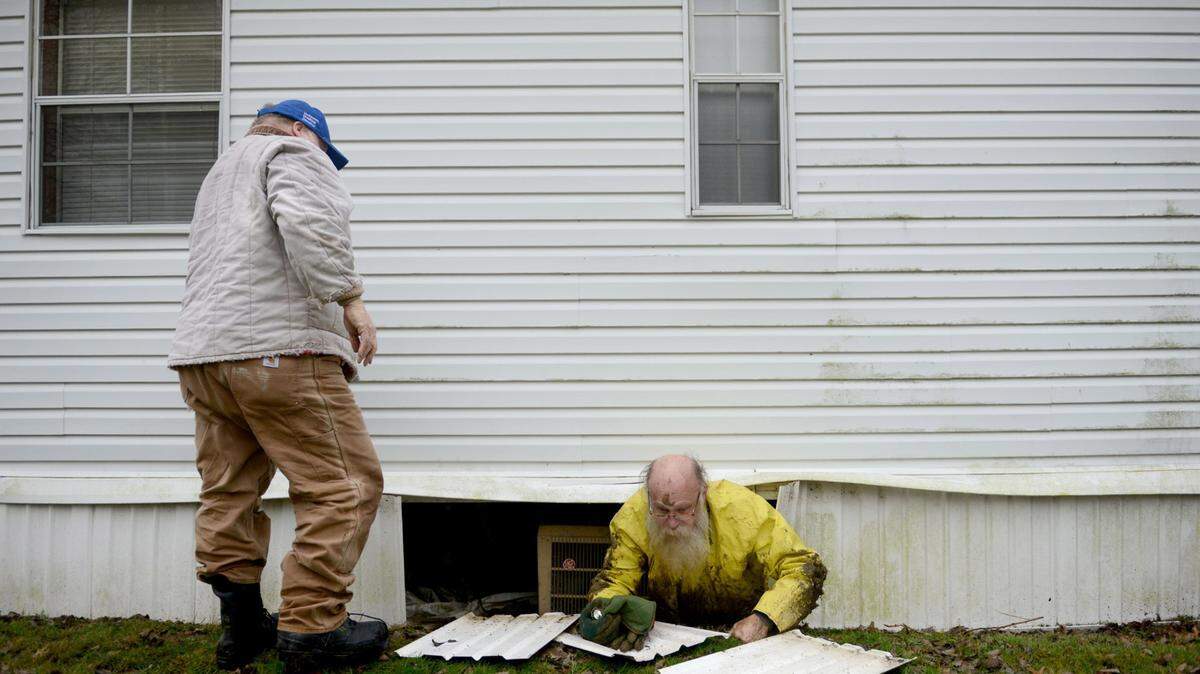 Lewis Jim Fogle crawls out form beneath the Indiana First Church of the Nazarene after volunteering to fix a leaking water pipe. He hasn't found a job since he was exonerated in September. (Michael Henninger/Pittsburgh Post-Gazette/TNS)