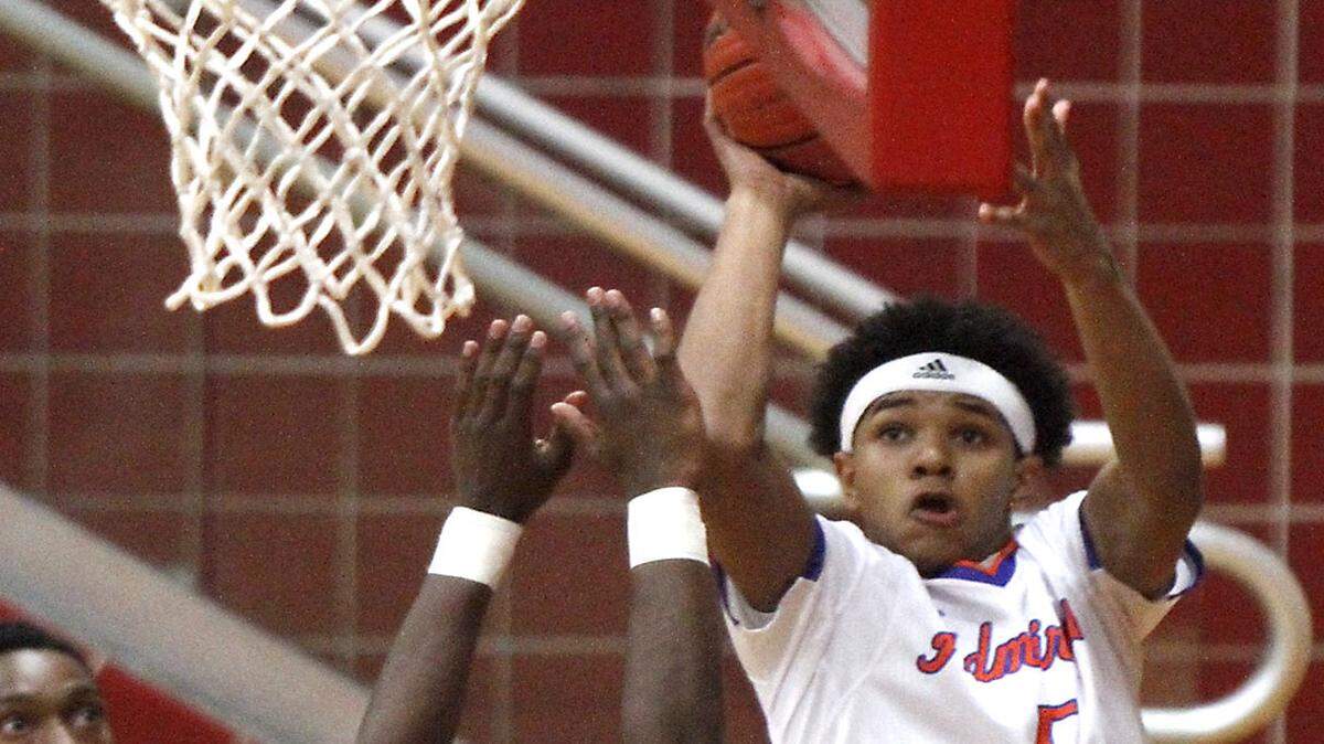 TIM ISBELL/SUN HERALD 
 Miles Daniels of Gulfport takes a shot from behind the backboard against Johnnelius Anderson of St. Martin, Monday, Jan. 18, 2016.
