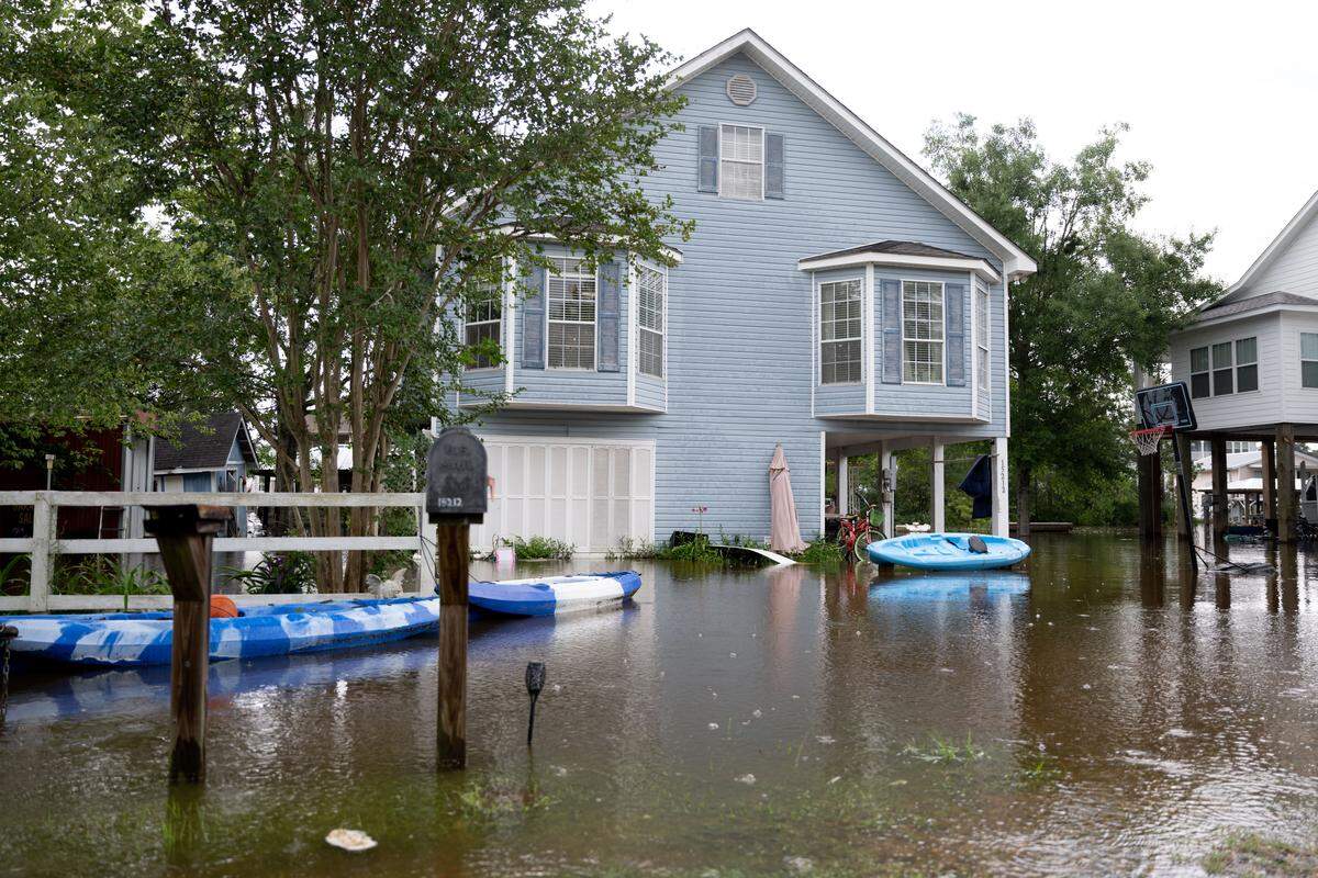 A home is surrounded by water from the Jourdan River along Highway 603 in Kiln on Tuesday.