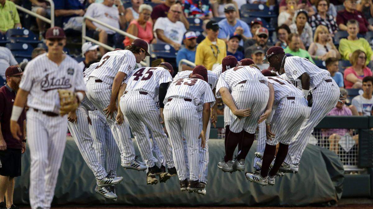 Mississippi State players participate in a warmup exercise between innings during an NCAA College World Series baseball game against Washington in Omaha, Neb., on June 16.