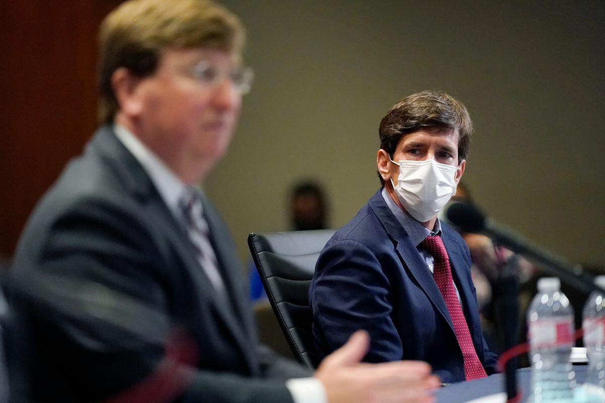 State Health Officer Dr. Thomas Dobbs, right, listens as Mississippi Gov. Tate Reeves explains his rationale for not ordering a statewide mask mandate as some health officials have recently called on him to do so, during his COVID-19 briefing before reporters, Tuesday, Nov. 24, 2020 in Jackson, Miss.