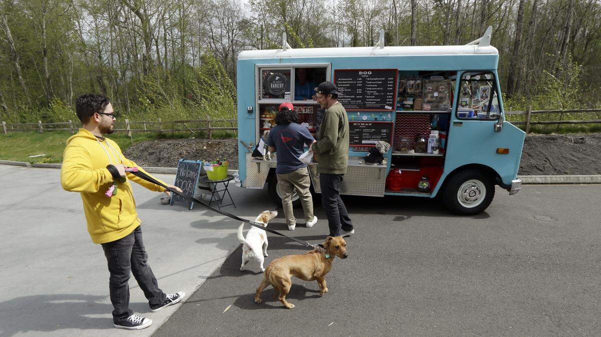TED S. WARREN/AP PHOTODog owners line up at a food truck specializing in treats for their four-legged friends during the lunch hour at the headquarters for the clothing and skateboard retailer Zumiez, in Lynnwood, Wash. The Seattle Barkery serves dogs and their owners at Seattle-area dog parks, office building parking lots, farmers markets and private events.