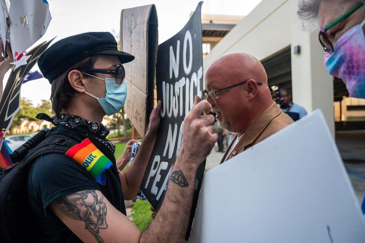 Two demonstrators have an altercation at the base of the Confederate monument during a protest to remove it in front of the Harrison County Courthouse parking lot in Gulfport on Thursday, Sept. 3, 2020.