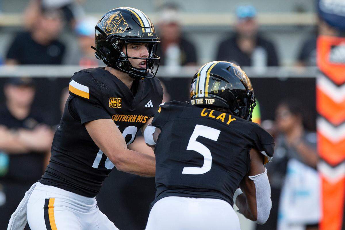 Southern Miss Golden Eagles quarterback Tate Rodemaker (18) hands the ball off to Southern Miss Golden Eagles running back Kenyon Clay (5) during a game between Southern Miss and Southeastern Louisiana at M.M. Roberts Stadium in Hattiesburg on Saturday, Sept. 7, 2024.