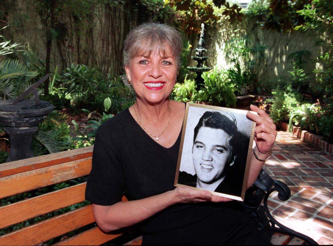 While relaxing in the courtyard at May Mahoney’s Old French House in Biloxi, June Juanico shows off a photo of her old boyfriend Elvis Presley, in this 1997 file photo.