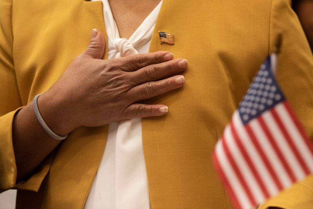 Flor Margarita Jefferson places her hand on her heart for the anthem after becoming an American citizen in a naturalization ceremony at Dan M. Russell Jr. Federal Courthouse in Gulfport on Friday, Oct. 7, 2022.