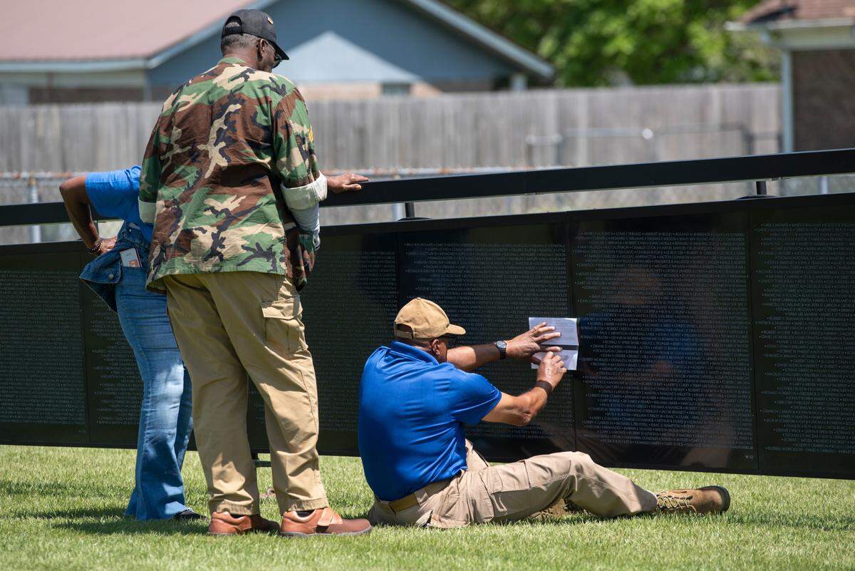 Rodney Gonsalves, the site manager for The Wall That Heals, a traveling three-quarter scale replica of the Vietnam Veterans Memorial in D.C., helps visitors do rubbings of names while it is on display at the D’Iberville Sports Complex in D’Iberville on Thursday, April 10, 2025.