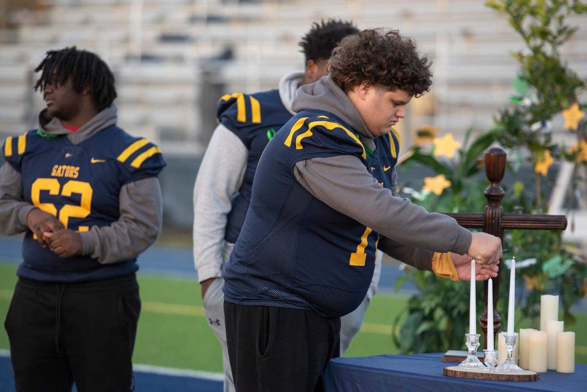 Shermarion Miner’s friends and teammates on the football team light candles during a vigil for the Gautier High School student at Gautier High School on Thursday, Jan. 16, 2025. Miner died suddenly after working out in the high school field house.