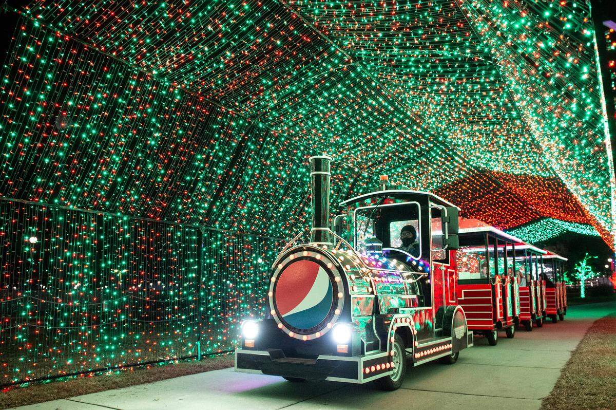 The Christmas train passes through some of the more than one million lights at Gulfport Harbor Lights at Jones Park each year.