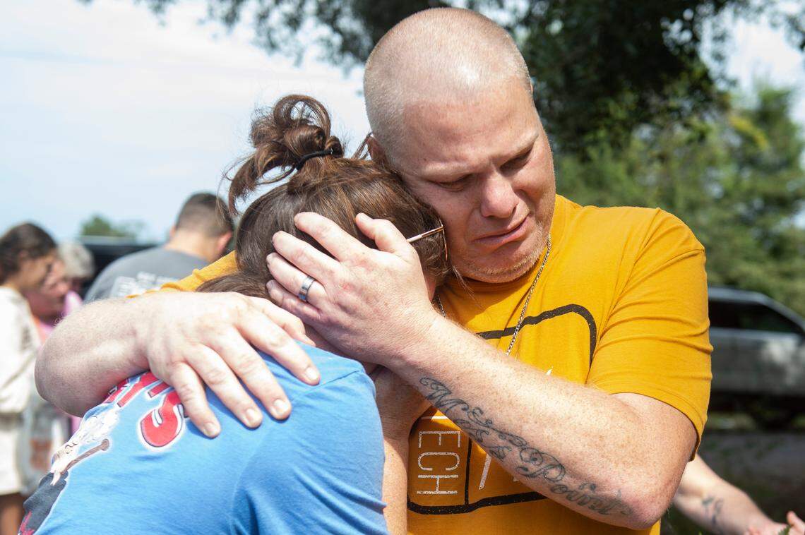 The parents of Baleigh Bowlin hug at the site of a fatal car accident that claimed the lives of their daughter and her best friend, Chloe Taylor, off of Highway 613 in Hurley on Monday, Oct. 17, 2022.
