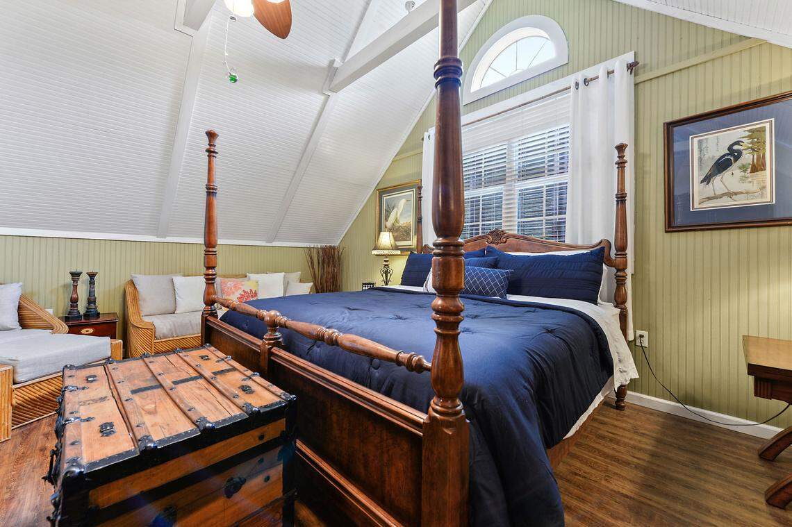 An upstairs bedroom with gabled ceiling at Breezy Porches, a unique log-sided home on Nicholson Avenue in Waveland.