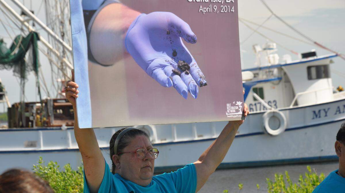 JEFF CLARK/SUN HERALD 
 Shrimp boat owner Melonie Johnson peacufully protests the BP oil spill during a six-year anniversary service.