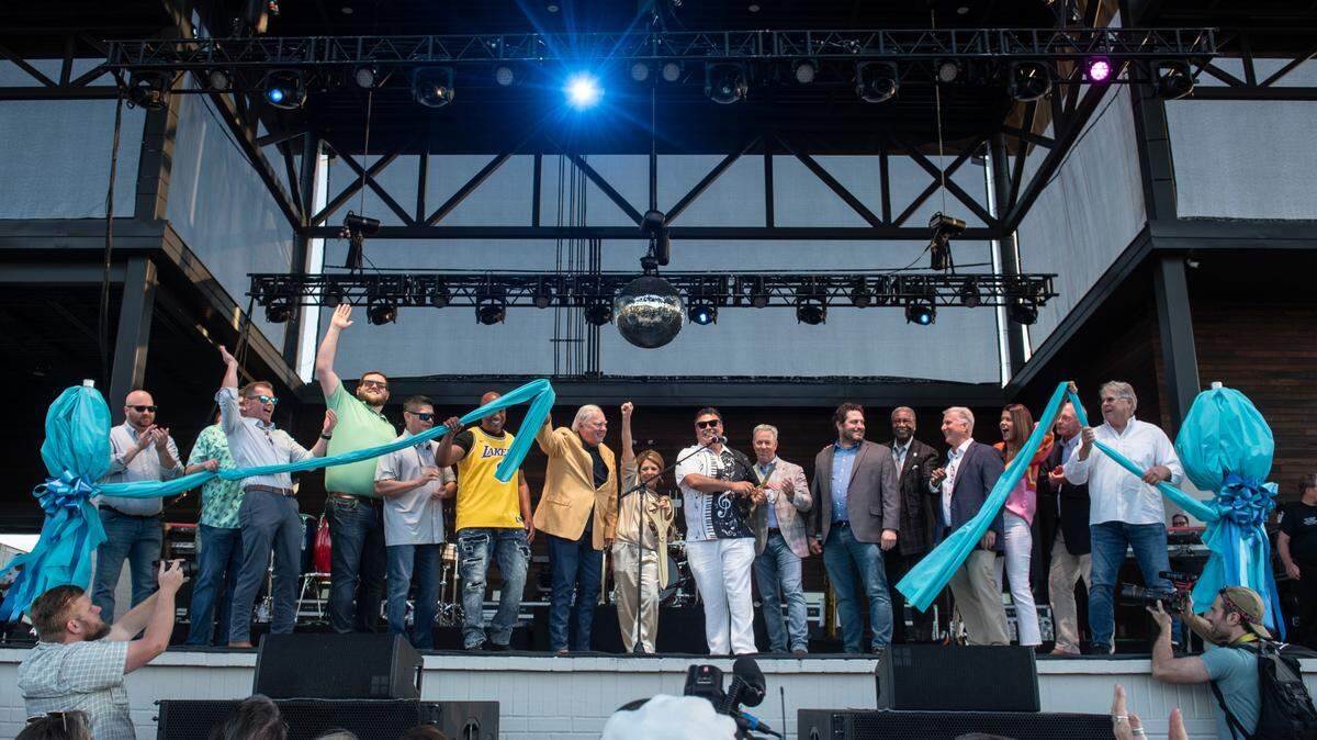City leaders from several Coast communities help Gautier Mayor Casey Vaughn, in the black and white shirt and white slacks at center, and Gautier City Manager Paula Yancey, to his left with arm raised, cut the ribbon before the inaugural show at The Sound amphitheater in Gautier on Friday, April 12, 2024.