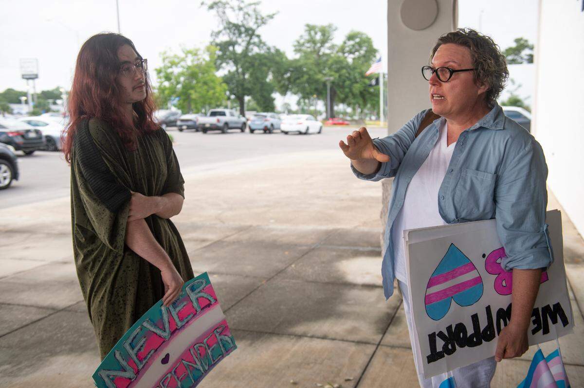 Hunter Thieme, a former student of the Harrison County School District who is transgender, talks with a member of the Mississippi Rising Coalition outside a Harrison County School Board meeting at the Central Office in Gulfport on Monday, June 5, 2023. LGBTQ+ advocates showed up at the meeting to request a change in the school’s graduation dress code after several transgender and cisgender students were prevented from walking in graduation due to their dress.