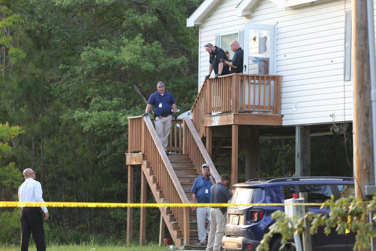 Crime scene tape blocks off the residence that Lawrence Bottoms fled from before being shot and killed in an officer-involved shooting. The door shows shattered glass where Harrison County deputies threw tear gas into the home.