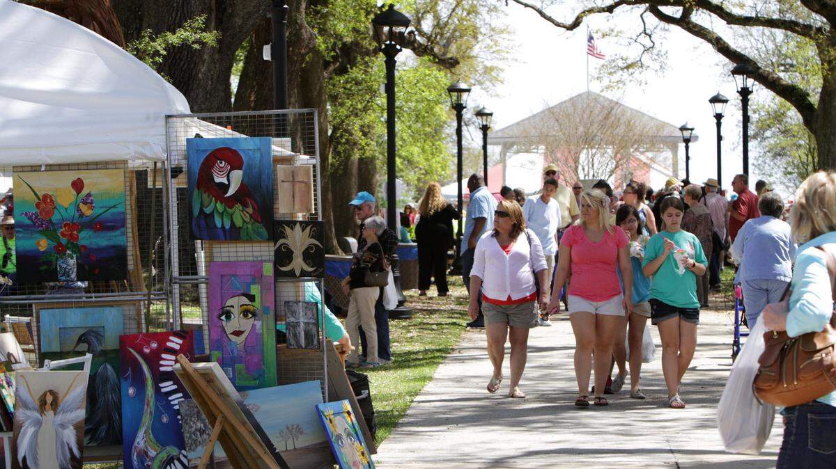 JOHN FITZHUGH/SUN HERALD/FILEVisitors stroll under the oaks at a past Art in the Pass art festival at War Memorial Park in Pass Christian. This year's event is Saturday and Sunday.