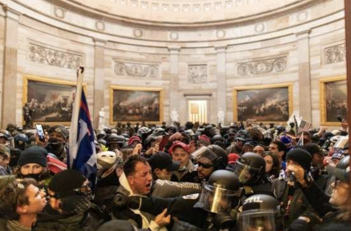 James McGrew, center in gray jacket, is seen pushing against police officers inside the U.S. Capitol on January 6, 2021.