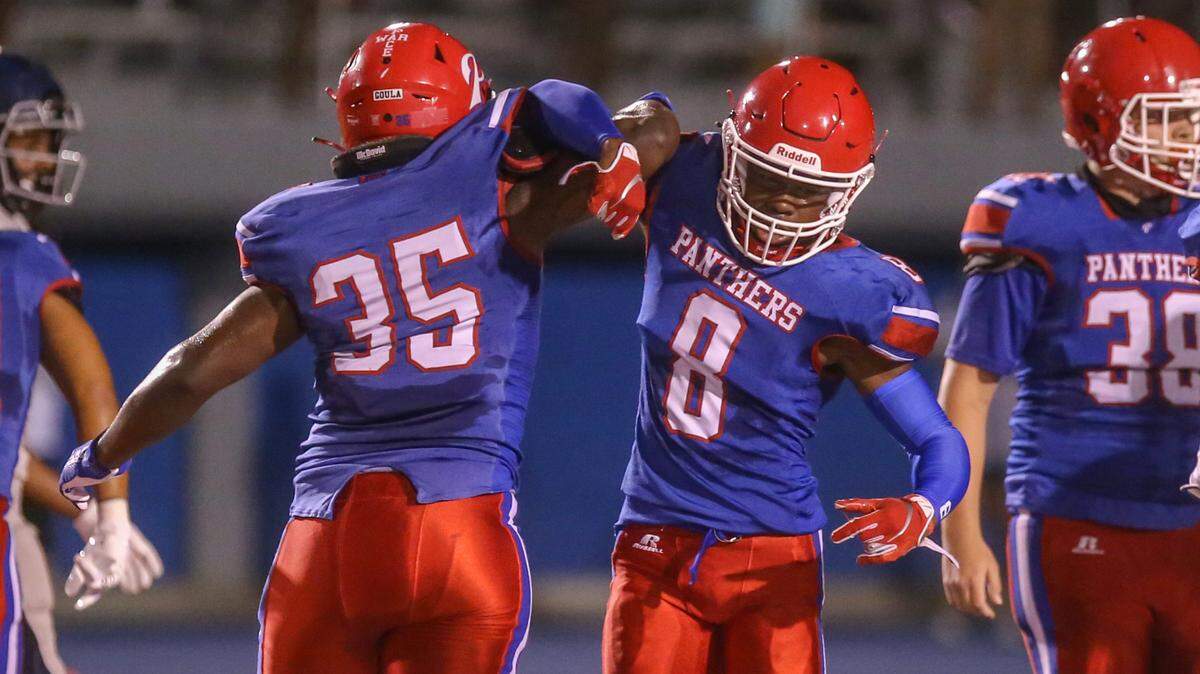 Isaiah Jackson (No. 8) and Andrew Luli (No. 35) celebrate a big defensive stop against Moss Point during their jamboree game August 28, 2020.