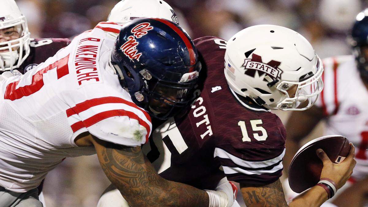 ROGELIO V. SOLIS/ASSOCIATED PRESS 
 Mississippi State quarterback Dak Prescott (15) is sacked by Ole Miss defensive tackle Robert Nkemdiche (5) during the Egg Bowl.