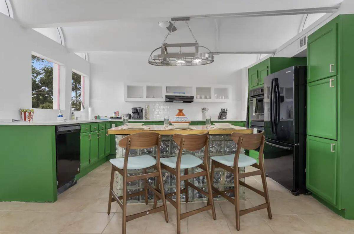 Pops of color, such as the bright green on the kitchen cabinets, appear throughout this Pass Christian house near the beach that is featured on Zillow Gone Wild social media accounts.