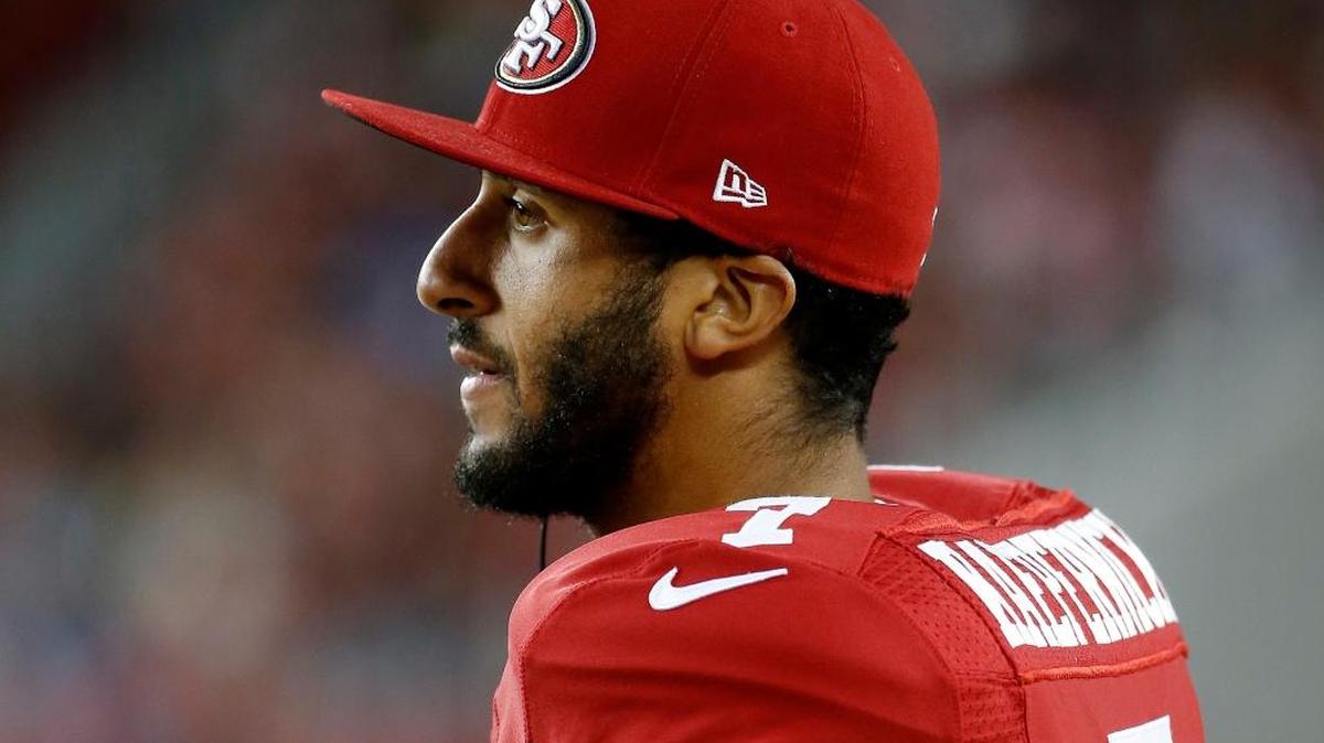 In this Sept. 3, 2015 file photo, San Francisco 49ers quarterback Colin Kaepernick watches from the sideline during the second half of an NFL preseason football game against the San Diego Chargers in Santa Clara, Calif. Kaepernick's decision this week to refuse to stand during the playing of the national anthem as a way of protesting police killings of unarmed black men has drawn support and scorn far beyond sports.